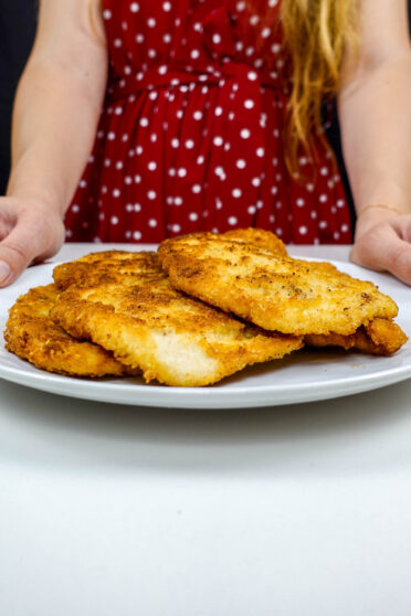 A plate full of turkey cutlets in Helena's hands