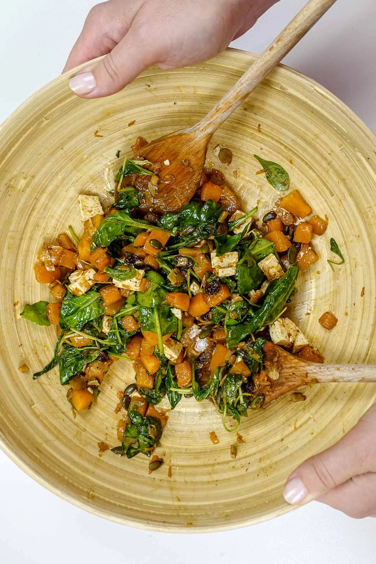 Helena is holding a big bamboo bowl of pumpkin feta salad