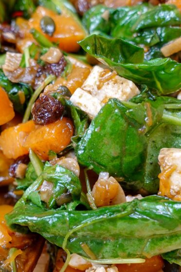 A closeup of salad with feta and raisins