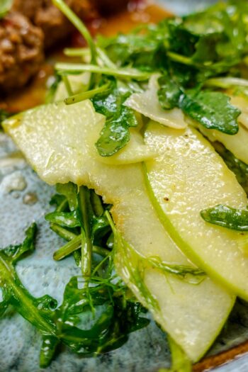Ready delicious fennel apple salad on a plate with arugula