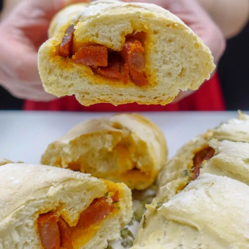 Helena is holding one chorizo bread and a plate of freshly baked chorizo bread