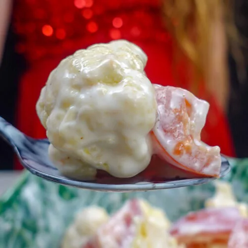 Helena is holding one teaspoon of fresh salad