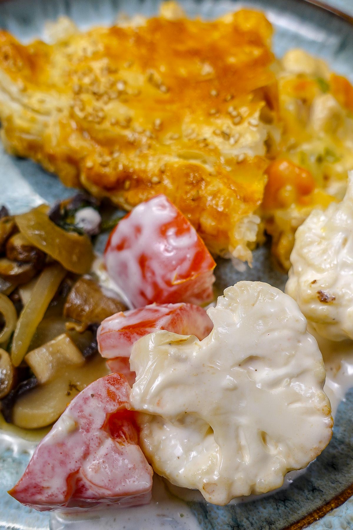 Cauliflower salad with tomatoes, with mushrooms and golden crust chicken pot pie on a plate