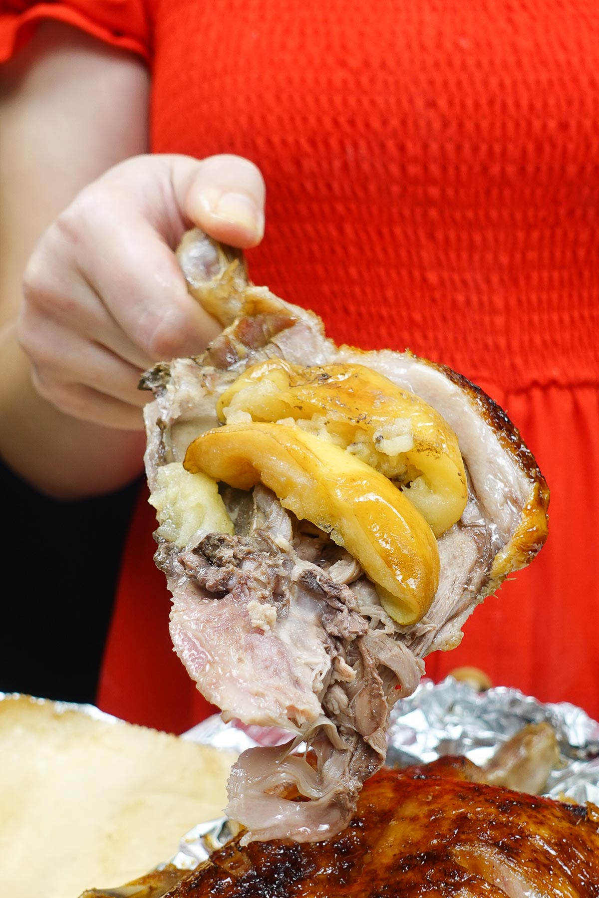 Helena is holding one duck leg perfectly cooked with apples on top