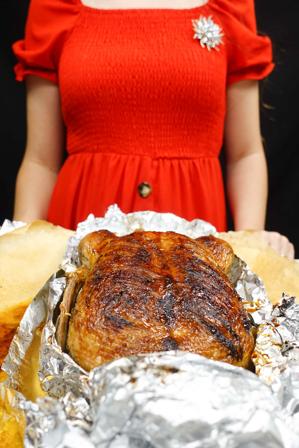 Ready roast duck on a tray and Helena is standing behind the tray