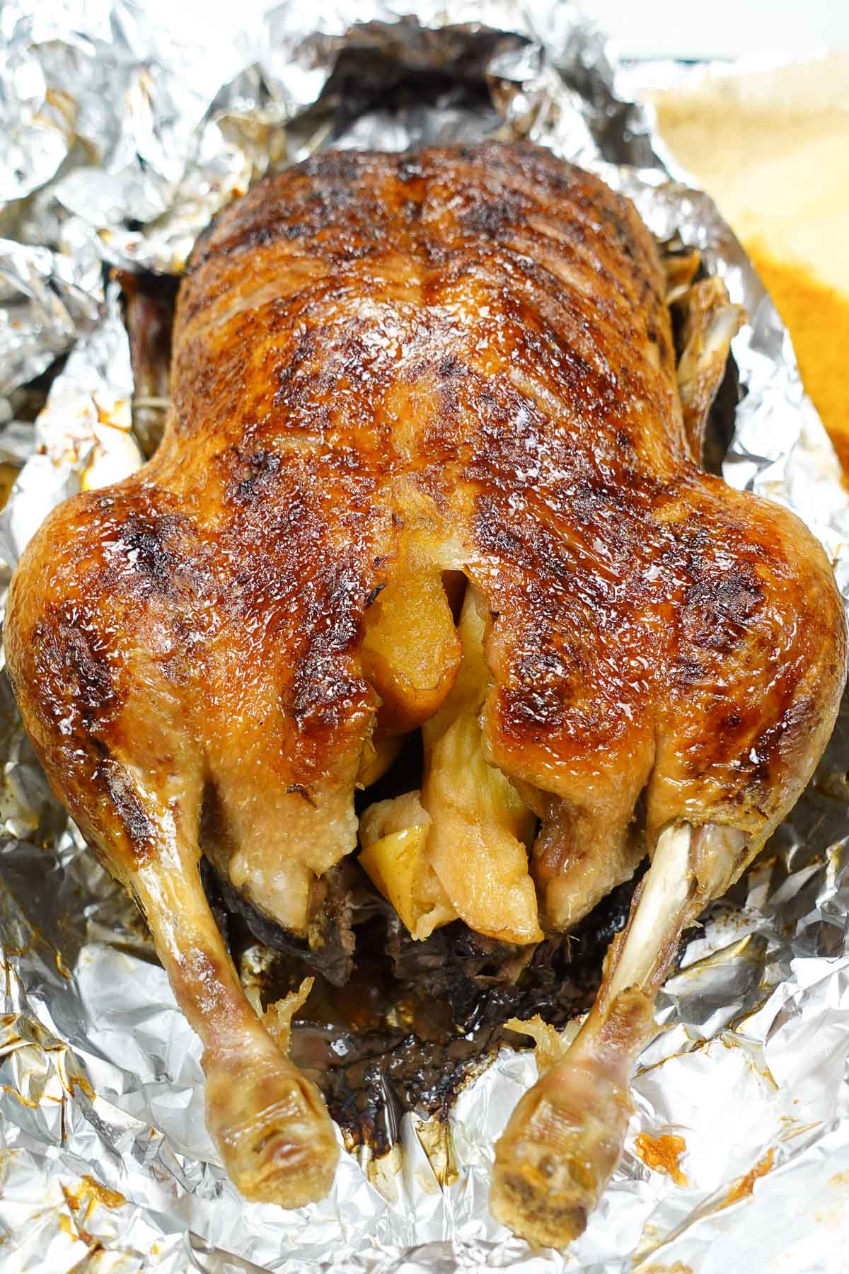 Juicy Roast duck on a tray with golden apples inside