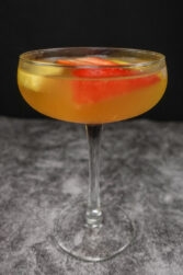 A coupe glass of Portuguese white sparkling sangria on a table