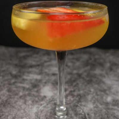 A coupe glass of Portuguese white sparkling sangria on a table