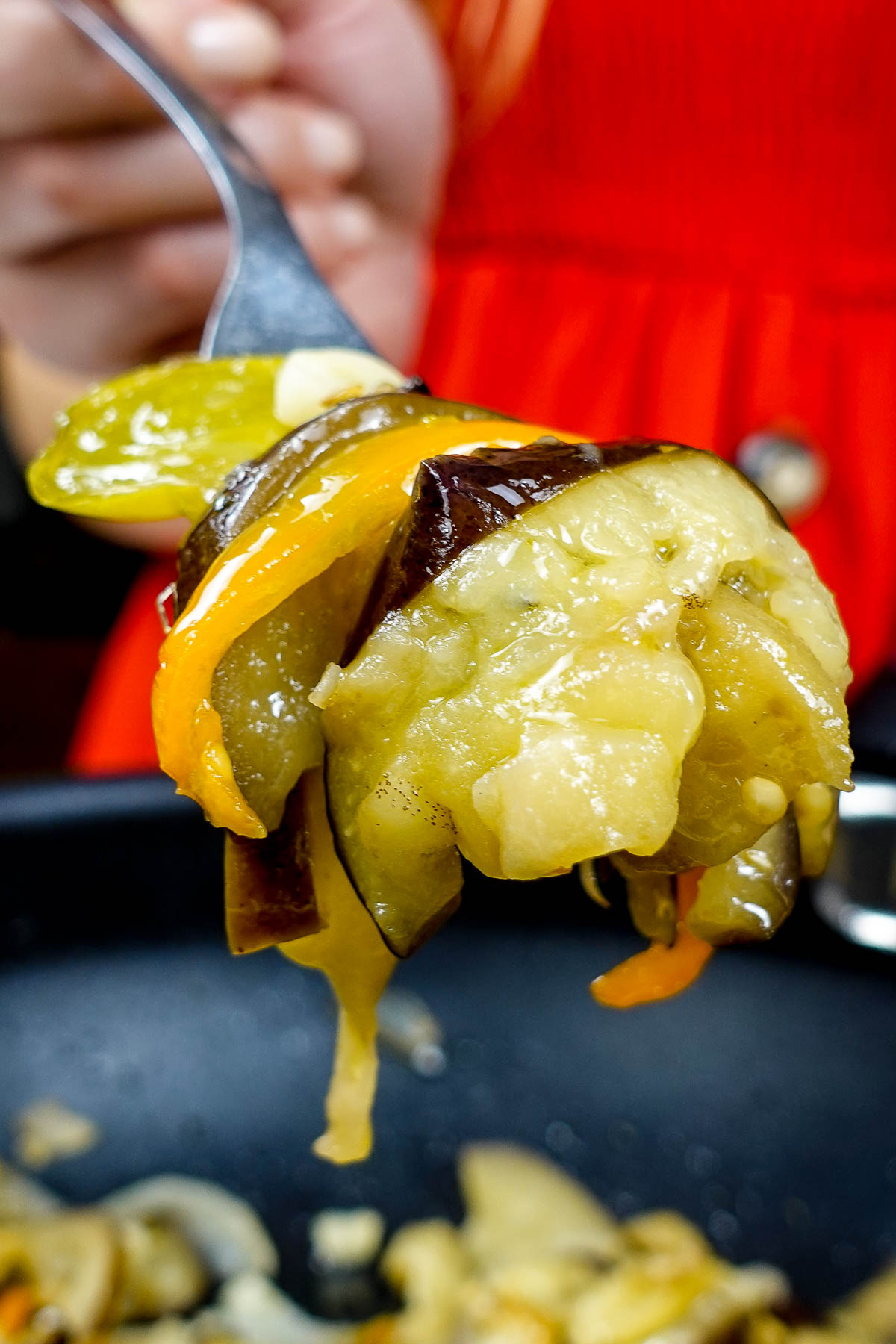 Helena is holding a fork full of vegetables