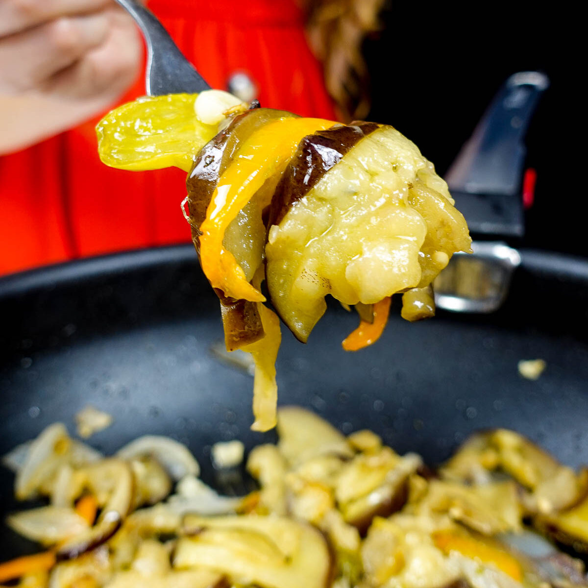 Helena is holding vegetables over the pot with sauteed vegetables