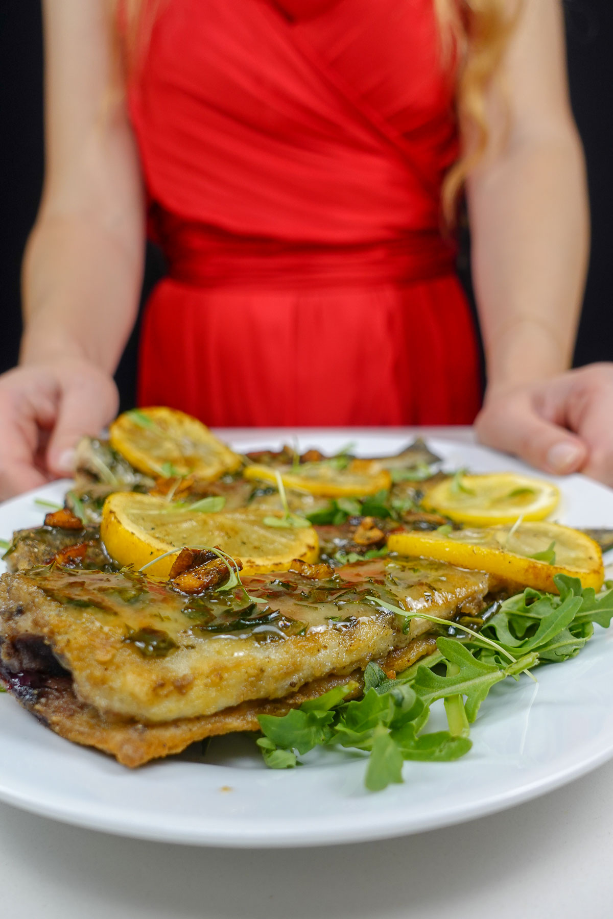 Helena is holding a plate with Trout in Lemon Garlic Sauce