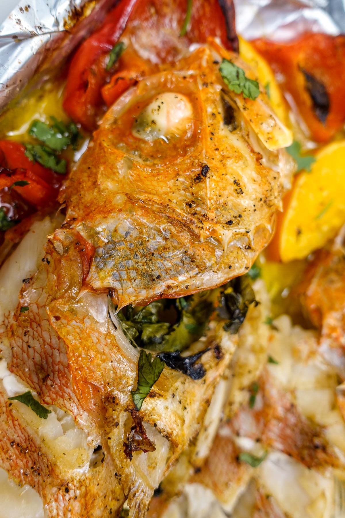 Deliciously baked rosefish on a tray with baked vegetables and citrus