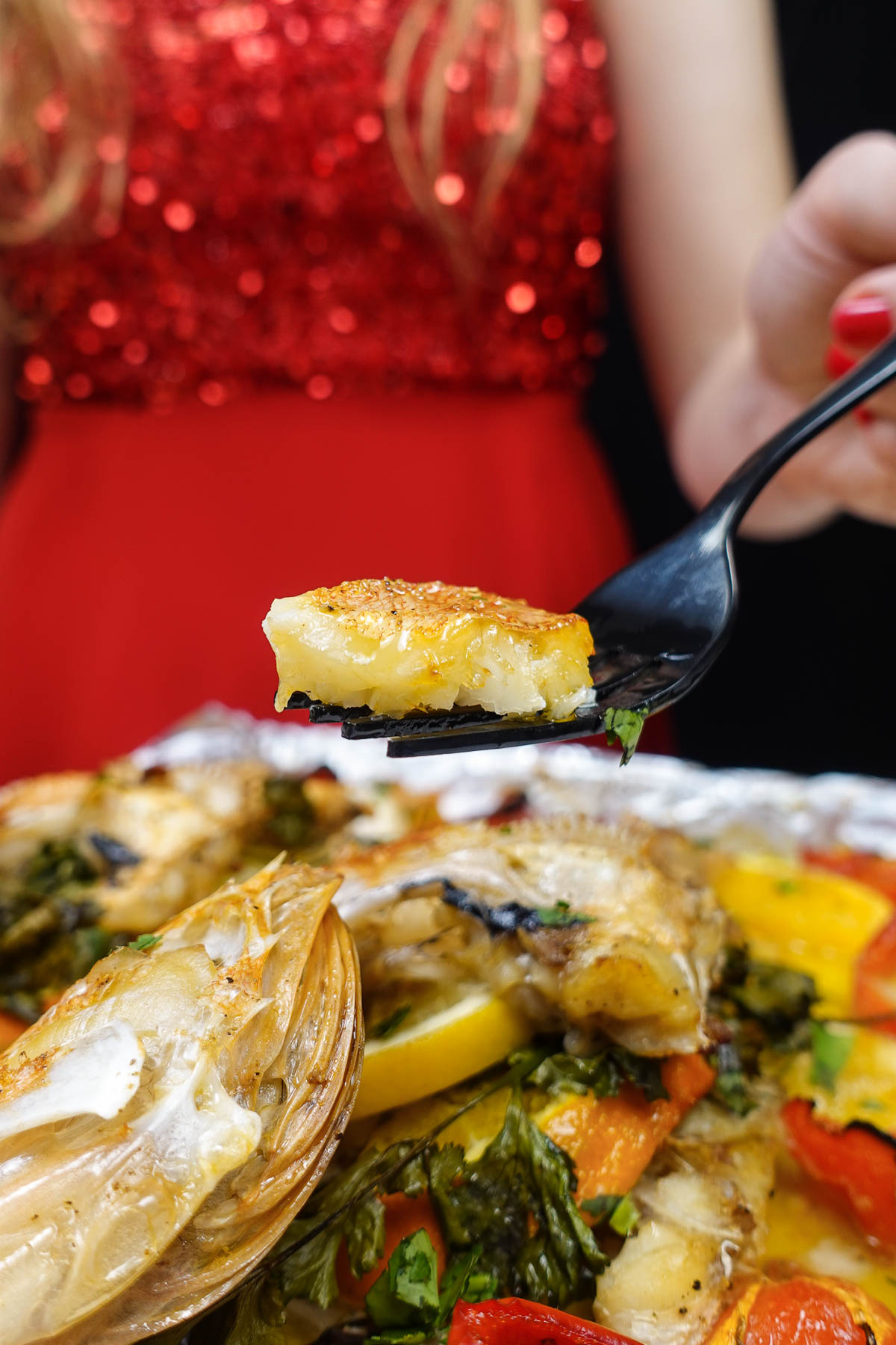 Oven baked rosefish on a fork in Helena's hand