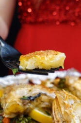 Helena is holding a fork with oven baked rosefish above the tray