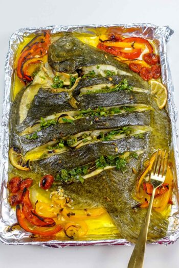 Delicious baked turbot with cherry tomatoes, peppers and green sauce