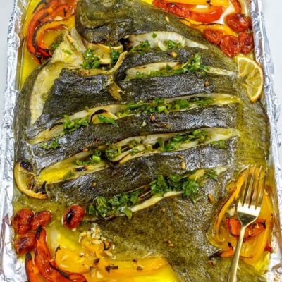 Delicious baked turbot with cherry tomatoes, peppers and green sauce
