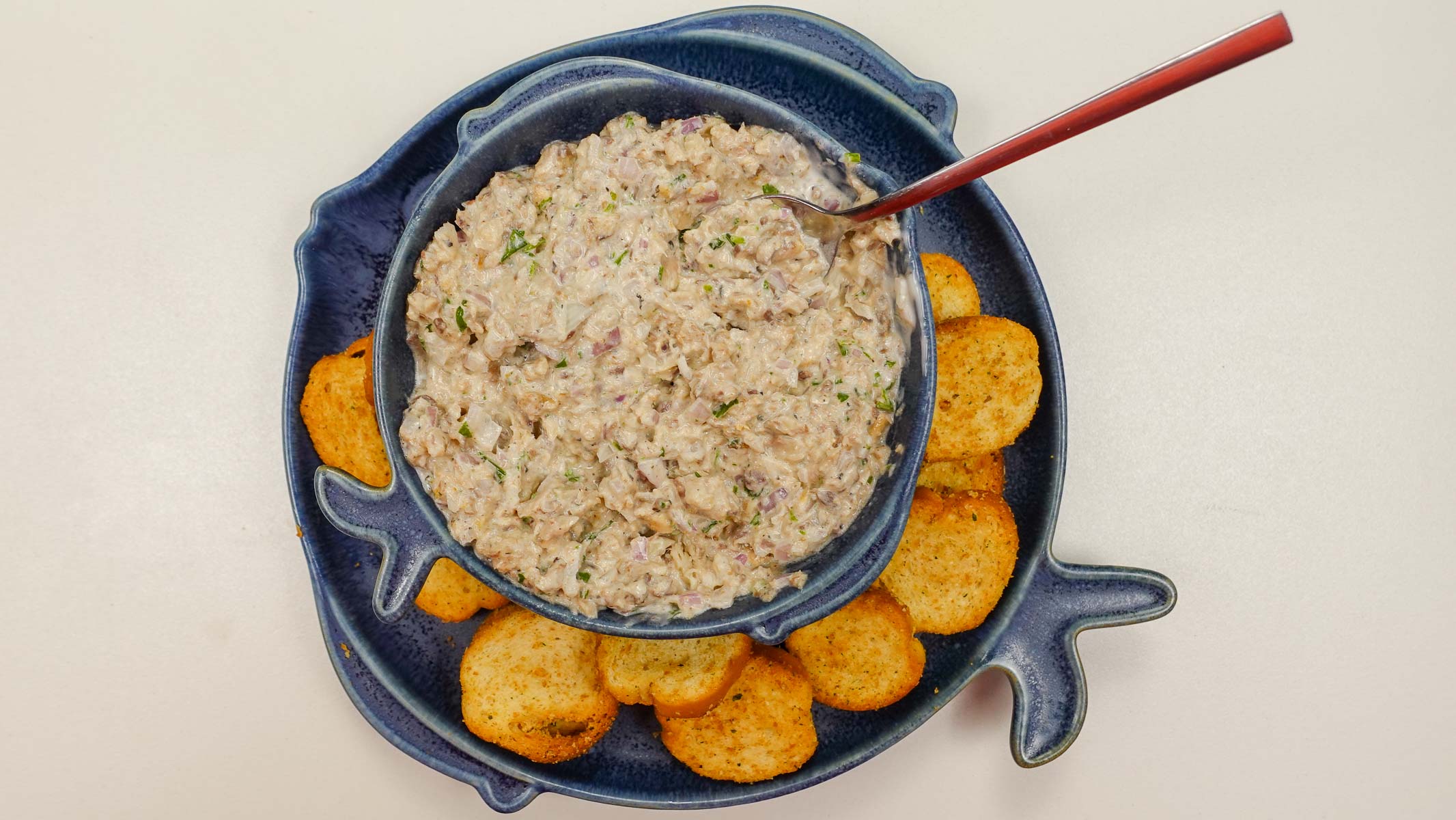 A bowl of Portuguese sardine pate with crackers on a side