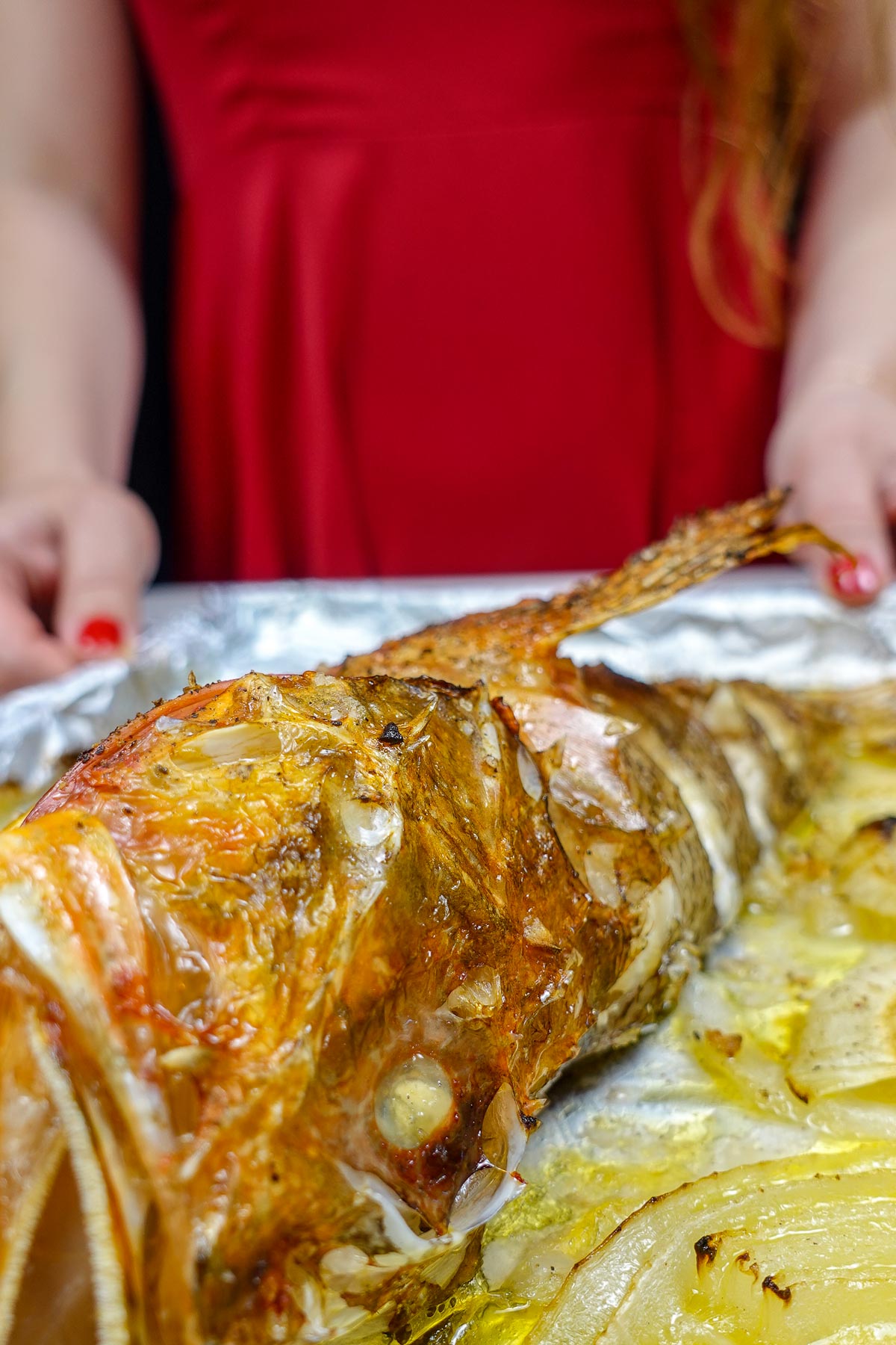Helena is holding a tray with delicious Mediterranean Baked with lemon and onion.