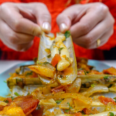 Helena is having one razor clam in tomato sauce in two hands
