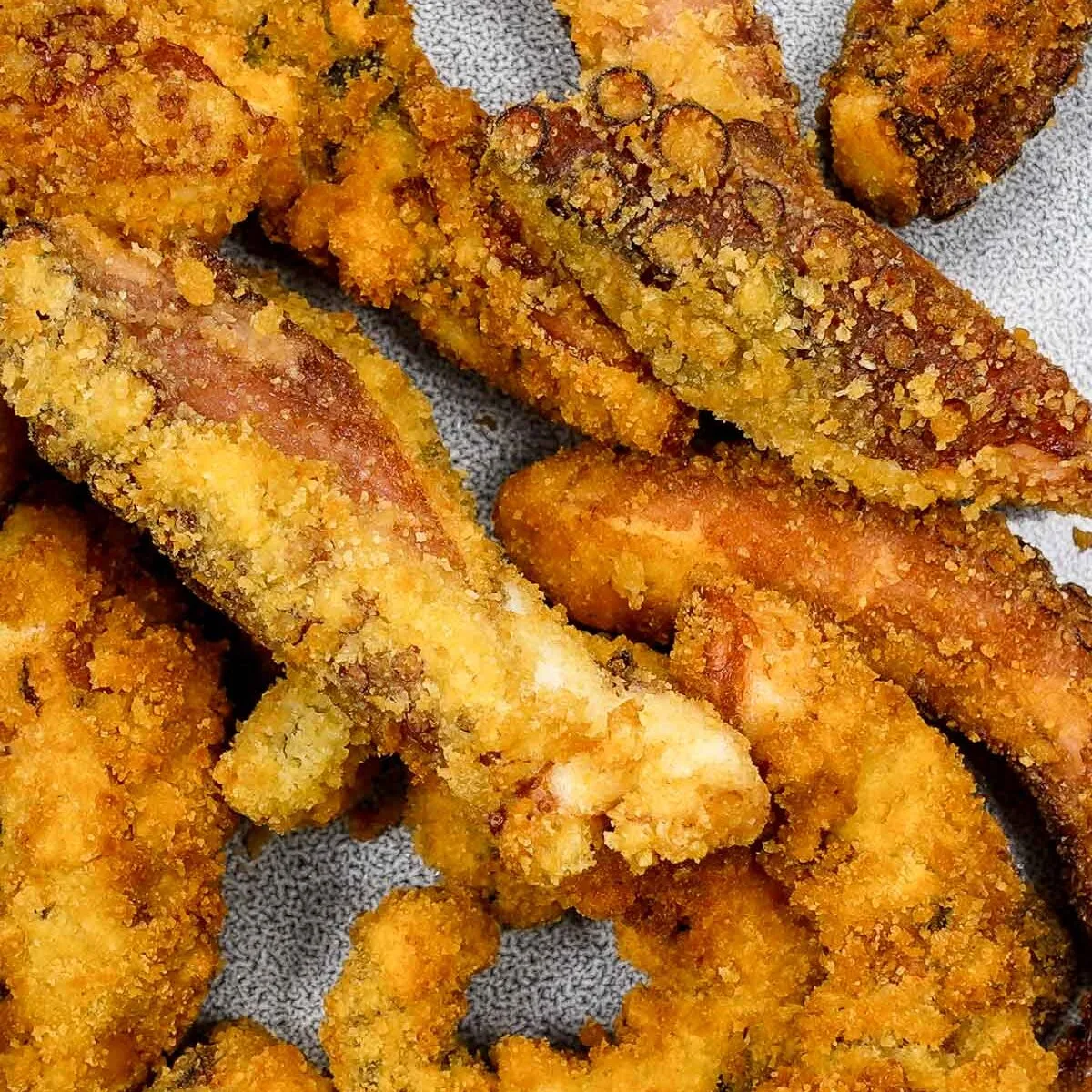 Crispy golden fried octopus pieces on a plate.