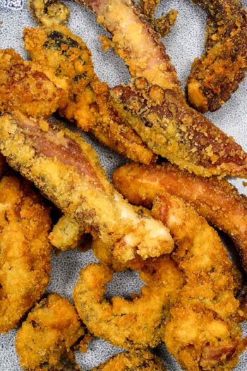 Crispy golden fried octopus pieces on a plate.