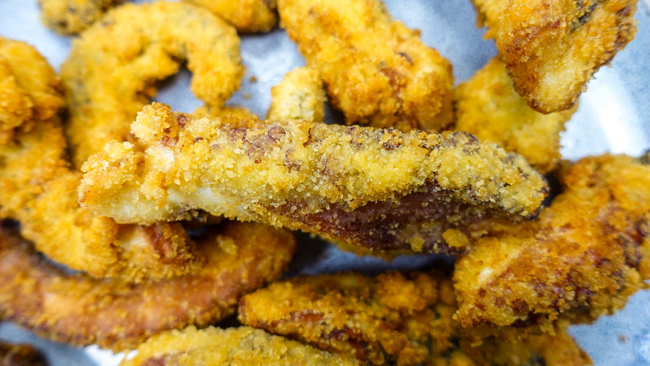 Golden crispy Portuguese fried octopus Polvo Panado pieces with crunchy breading.