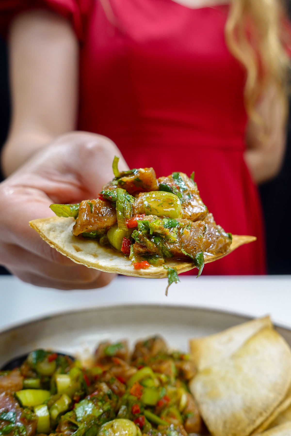 Mediterranean tuna tartare served on a crispy chip held by Helena.