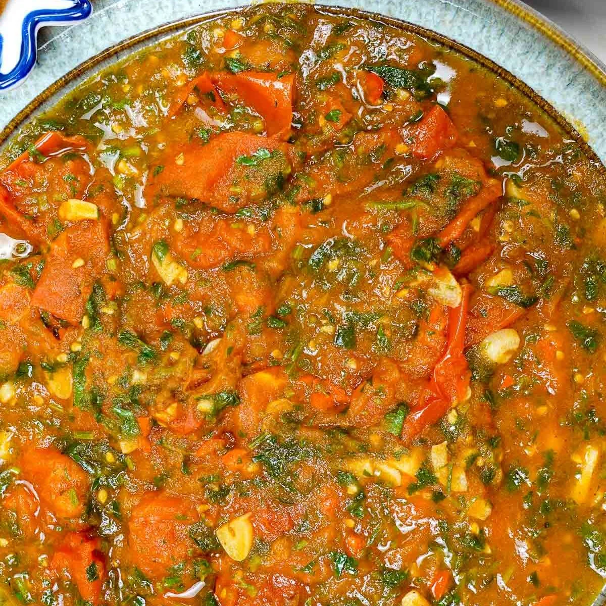 Spicy tomato sauce with cilantro in a ceramic bowl.