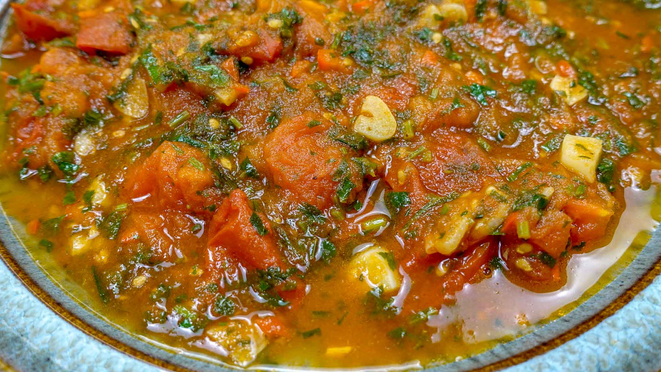 A bowl of spicy tomato sauce in a green bowl.