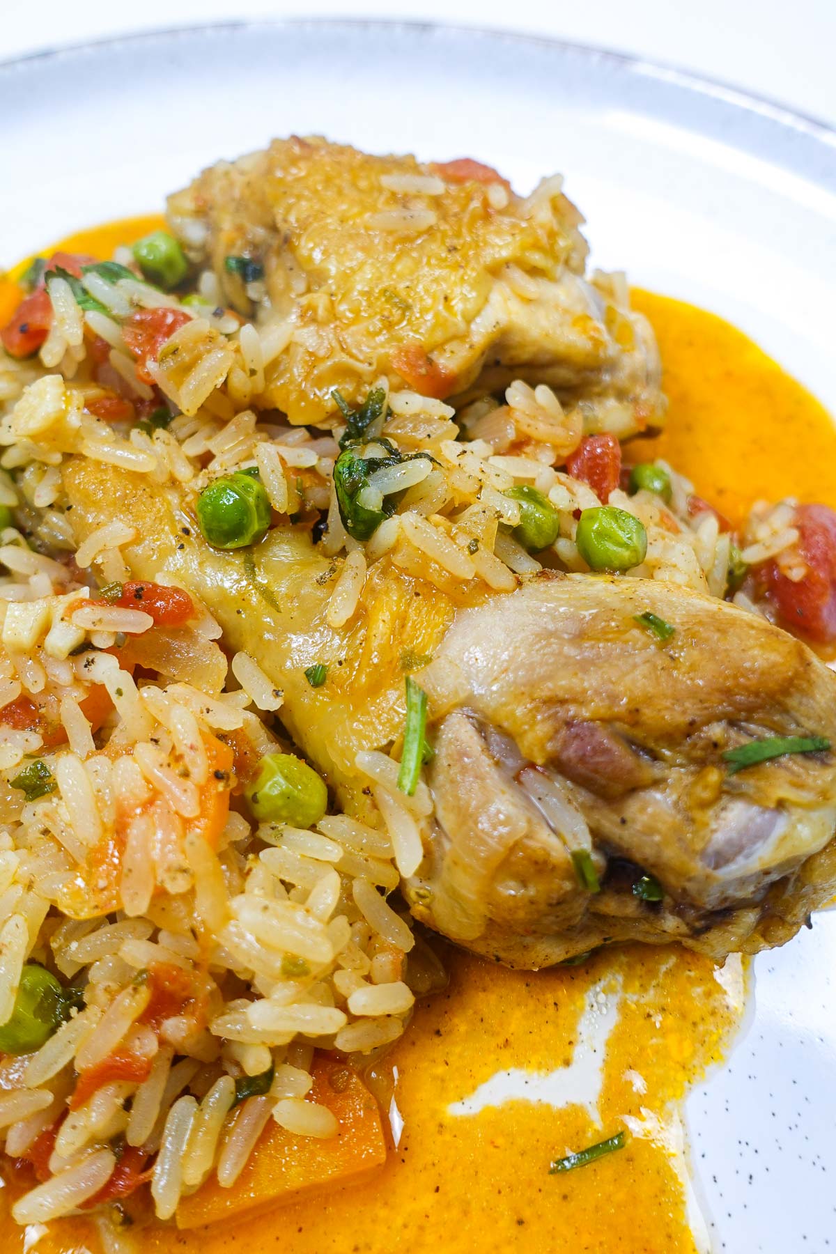Portuguese chicken with seasoned rice and mixed vegetables on plate.