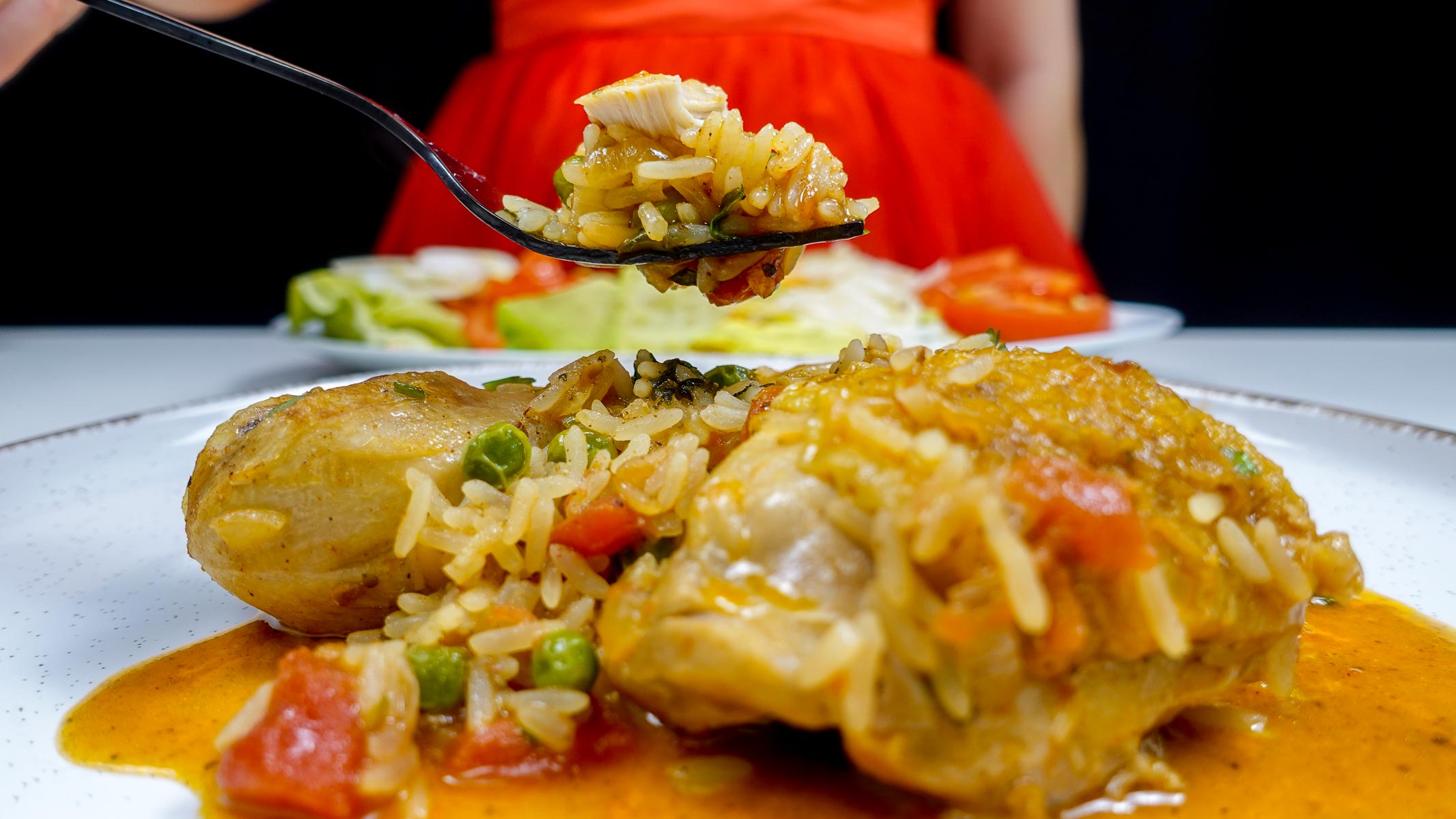 Portuguese chicken with rice and vegetables on a white plate.