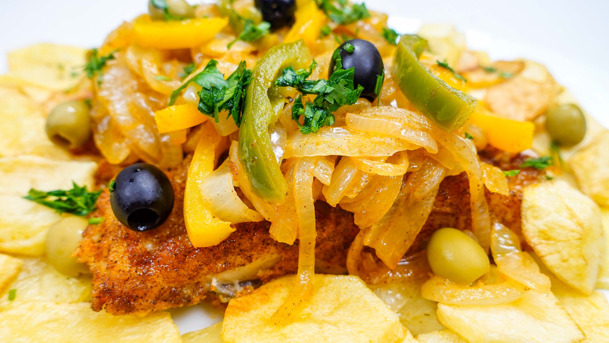 Crispy fried cod topped with sautéed onions, peppers, and olives.