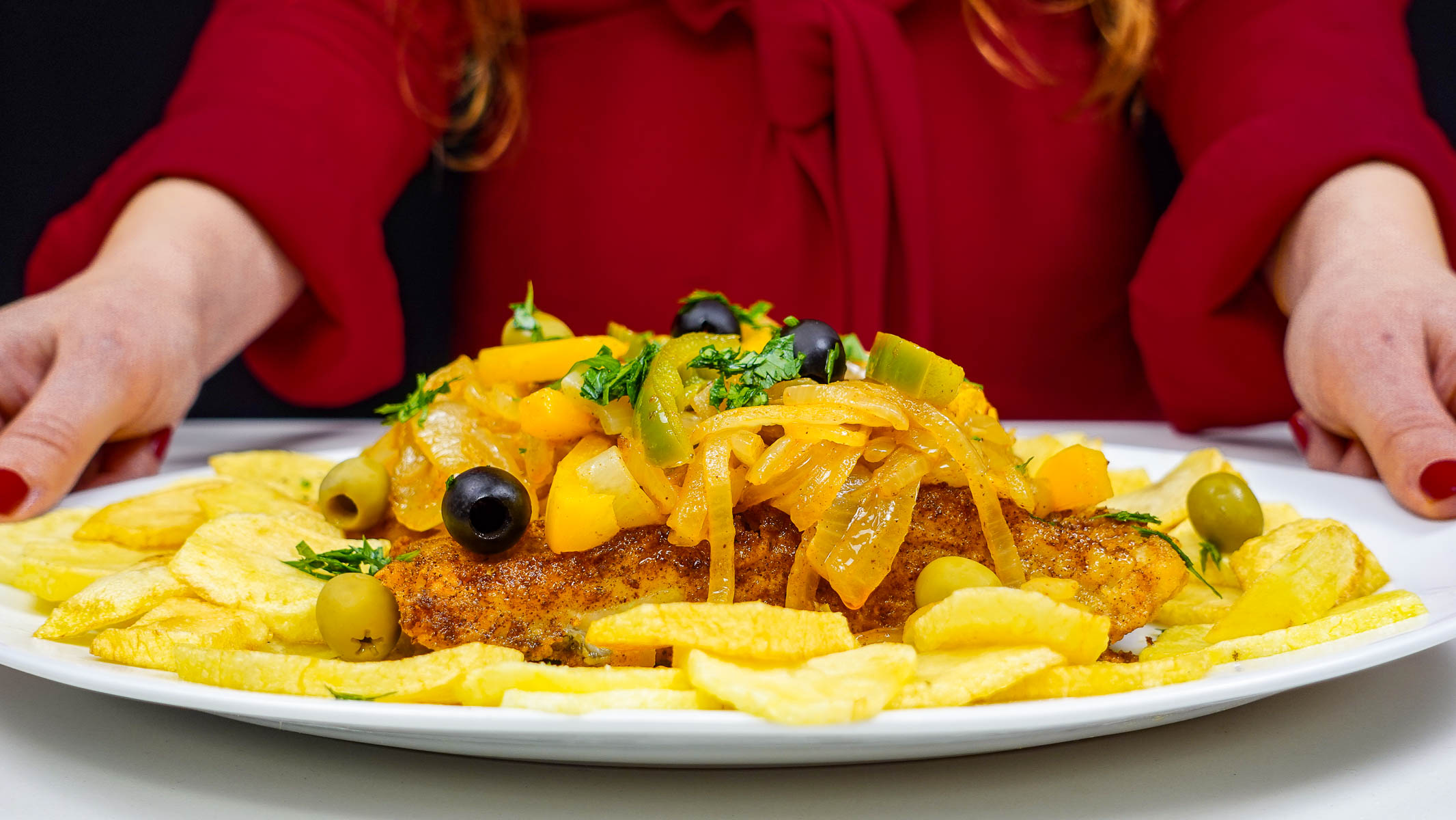 Crispy fried cod topped with sautéed onions, peppers, and olives on fries.