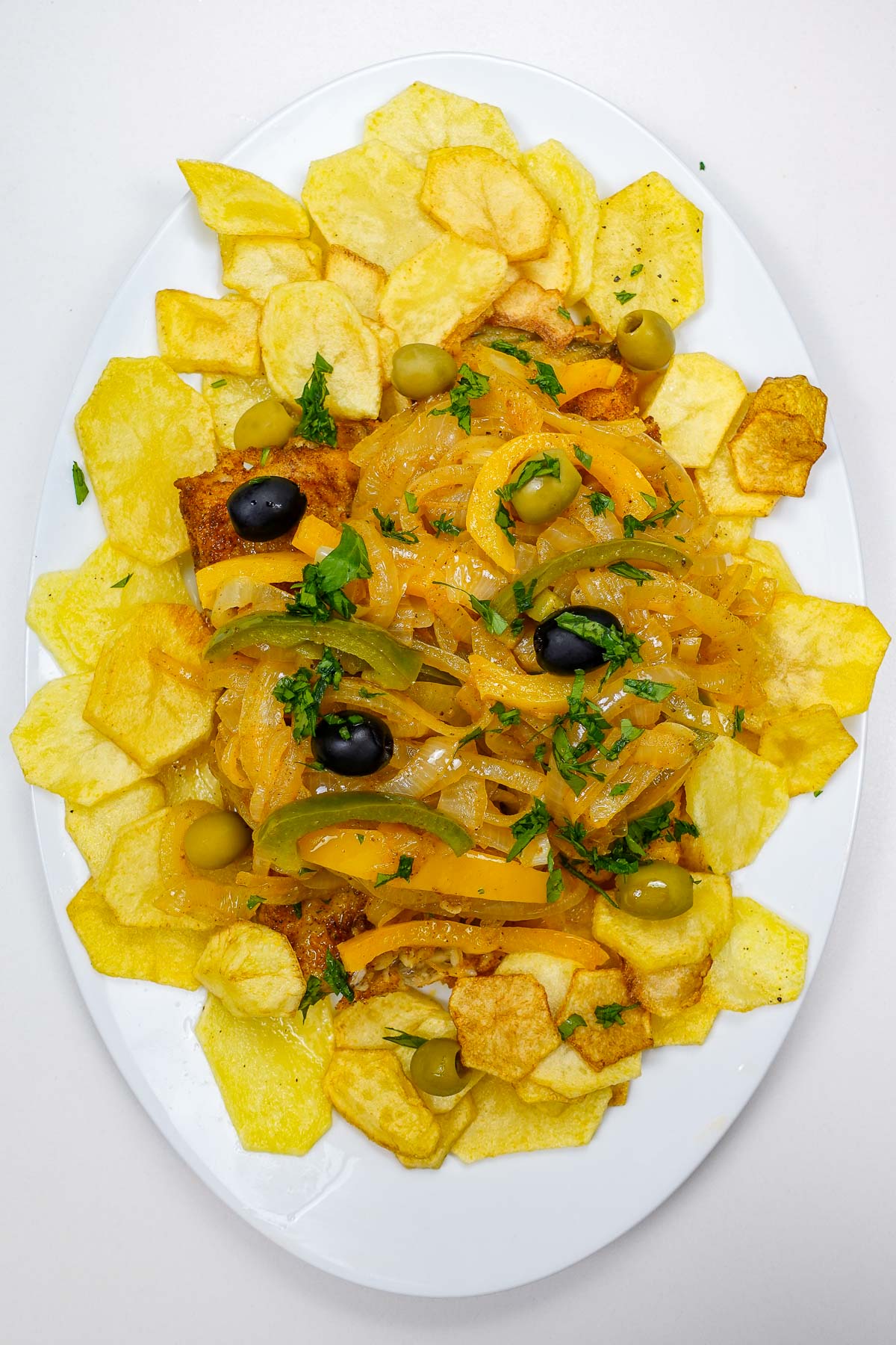 Cripsy Fried Cod with Potatoes and Onions on a plate.